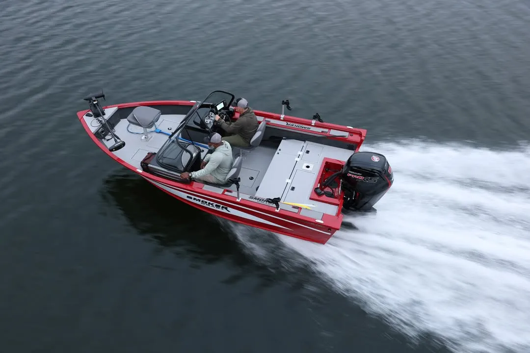 Two people riding a red motorboat on the water